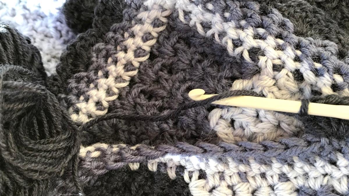 A crochet blanket with a hook