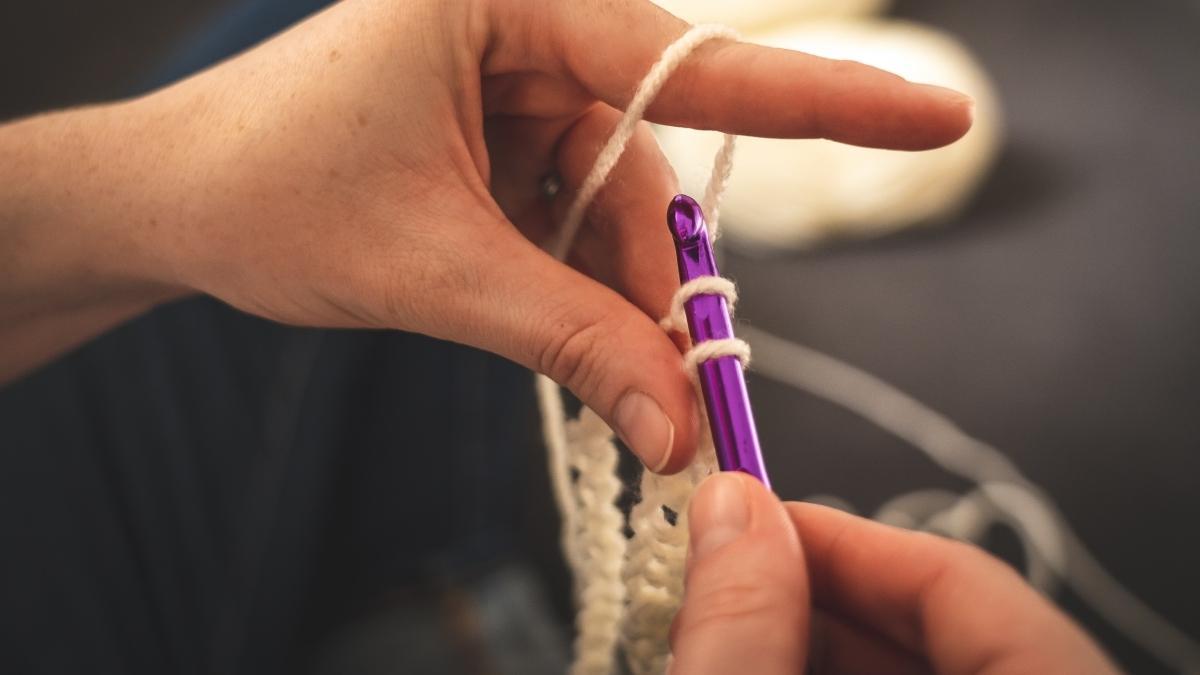 Person using a crochet hook to keep the crochet tight