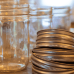 empty canning jars beside stack of lids